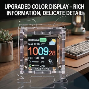 Puede incluir: Pantalla digital de acrílico transparente que muestra la fecha, la hora y la información meteorológica. La pantalla dice "UPGRADED COLOR DISPLAY - RICH INFORMATION, DELICATE DETAIL". La temperatura es de 7°C. La pantalla está sujeta en un marco de acrílico transparente con herrajes dorados.