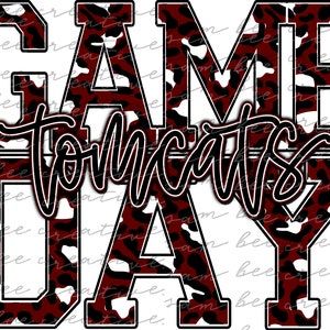 May include: Red and white leopard print graphic with the text "GAME DAY" and "TOMCATS" in black lettering.