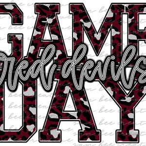 Puede incluir: Un gráfico de estampado de leopardo marrón, negro y blanco con el texto "GAME DAY" y "red devils" en una fuente de letra cursiva gris.