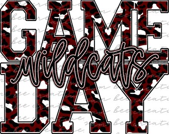 Puede incluir: Un gráfico de estampado de leopardo rojo y blanco con el texto "GAME DAY" y "WILDCATS" en letras negras delineadas.