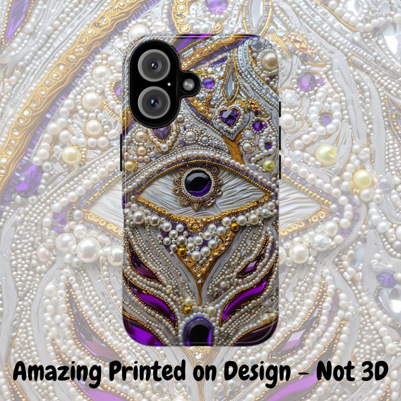 May include: A phone case with an ornate design featuring white, gold, and purple elements. The case has a central eye motif with a black center, surrounded by pearls and gems. The text "Amazing Printed on Design - Not 3D" is at the bottom.