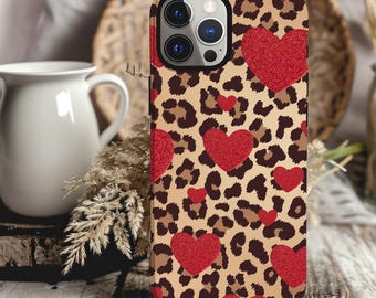 May include: A brown and black leopard print phone case with red glitter hearts. The case is designed for an iPhone.