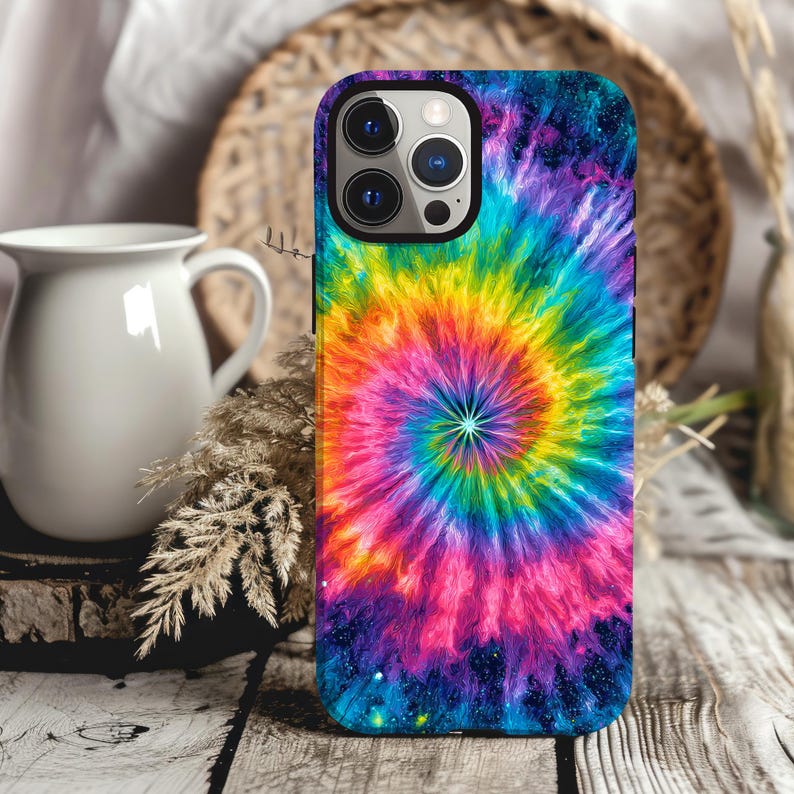 May include: A colorful phone case with a vibrant tie-dye spiral design. The case features a spectrum of colors, including pink, yellow, orange, and blue, creating a psychedelic effect. The case is designed to fit a smartphone and has a black border.
