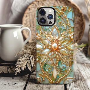 May include: A phone case with a decorative design featuring a large, iridescent flower with gold accents and a pearl-like center. The background is a mosaic of blue, green, and white tiles.