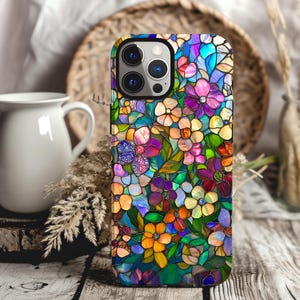 May include: A colorful phone case with a stained glass design featuring a variety of flowers in shades of pink, purple, blue, yellow, and green.