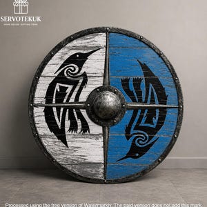 Peut inclure: Un bouclier rond en bois avec une finition vieillie, divisé en sections blanches et bleues. Chaque section présente un motif de corbeau noir. Le bouclier a un bord en métal et un bossage central. Le texte "SERVOTEKUK HOME DECOR - GIFTING ITEMS" est visible.
