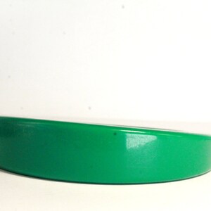 May include: A bright green plastic headband with a curved shape.