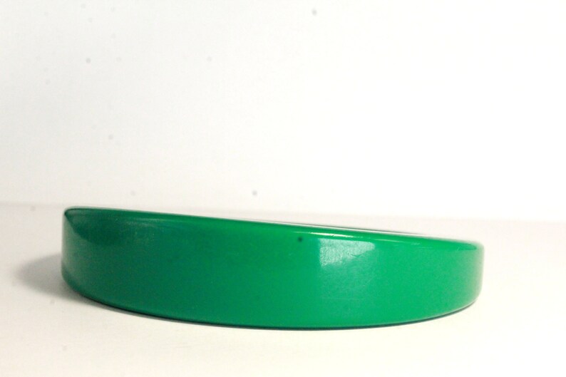 May include: A bright green plastic headband with a curved shape.