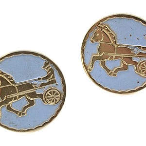 May include: Two gold-toned cufflinks with a light blue background and a brown horse-drawn chariot design. The cufflinks are circular with a detailed illustration of the horse and chariot.