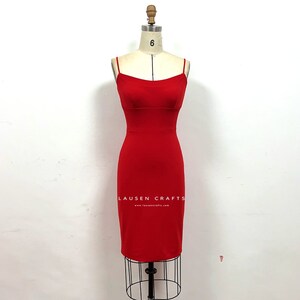 May include: A red sleeveless dress with a fitted silhouette and a scoop neckline. The dress is on a mannequin and the brand name "LAUSEN CRAFTS" is printed on the front of the dress.