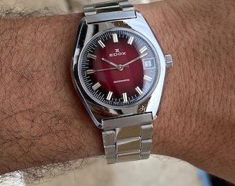 Reloj automático EDOX vintage – década de 1970, esfera roja con efecto rayos de sol, caja tipo cojín de fabricación suiza.