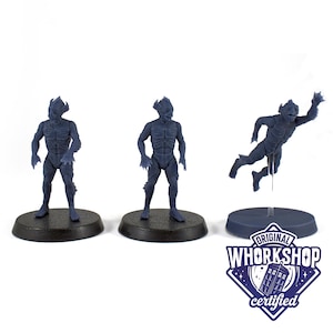Könnte beinhalten: Drei dunkelblaue Miniaturfiguren von humanoiden Kreaturen mit strukturierter Haut und Krallen an Händen und Füßen. Eine Figur ist in der Luft, unterstützt von einem Ständer. Die Basis jeder Figur ist schwarz. Das Bild enthält das Logo "Original Whorkshop Certified".