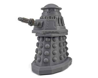 May include: A gray Dalek figurine, a fictional extraterrestrial race from the British science fiction television program Doctor Who. The figurine has a cylindrical body with a series of spherical protrusions, a gun-like arm, and a dome-shaped head.