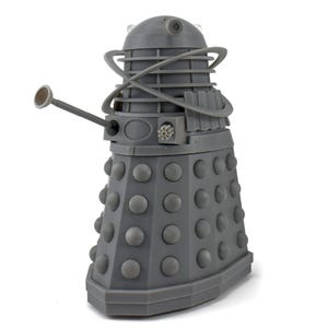 May include: A gray Dalek figurine, a fictional extraterrestrial race from the British science fiction television program Doctor Who. The figurine has a cylindrical body with numerous round, gray protrusions and a gun-like arm.