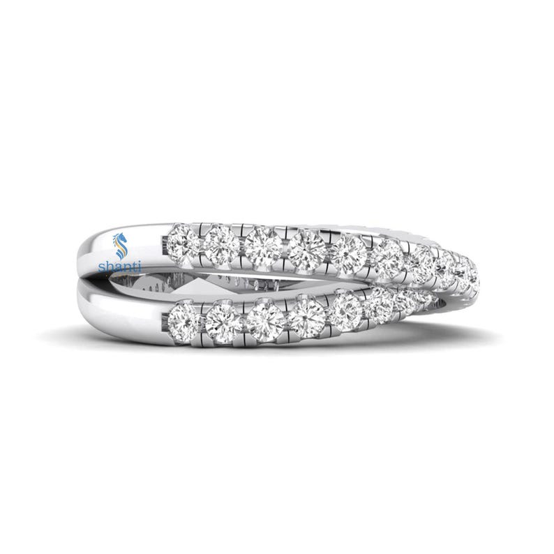 Puede incluir: Un anillo plateado con dos bandas, cada una incrustada con peque&ntilde;as piedras preciosas transparentes. Las bandas se entrelazan, creando un dise&ntilde;o &uacute;nico y elegante. El anillo se muestra sobre un fondo blanco, resaltando su brillo y detalle. La palabra "shanti" es visible.
