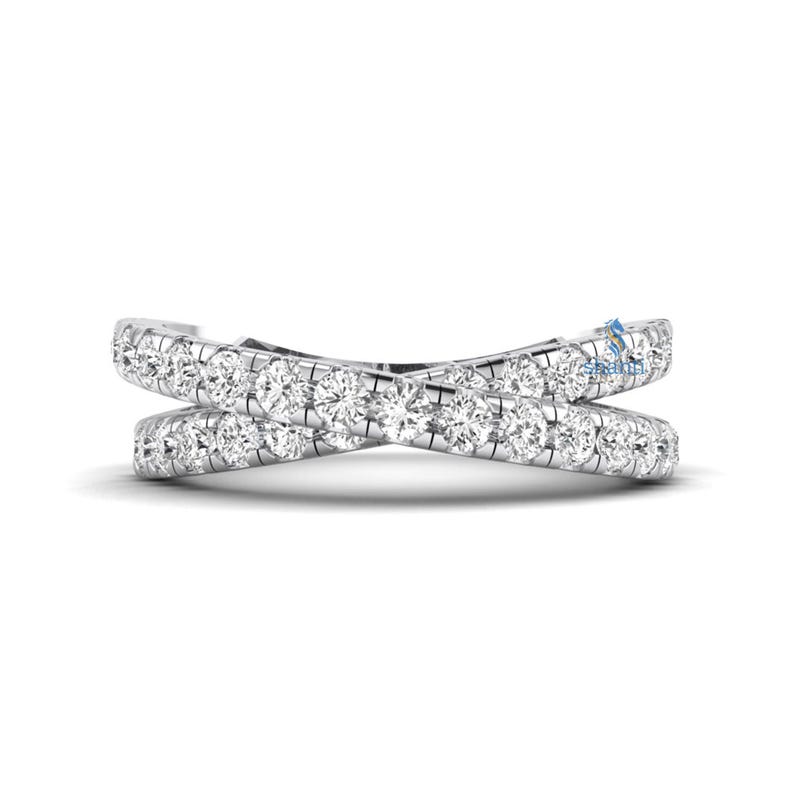 Puede incluir: Un anillo de oro blanco con un dise&ntilde;o cruzado, engastado con numerosas piedras preciosas peque&ntilde;as, redondas y transparentes. El dise&ntilde;o del anillo presenta dos bandas que se cruzan, formando una X. Las piedras preciosas est&aacute;n espaciadas uniformemente.