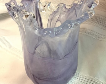 May include: A purple glass vase with a wavy, ruffled rim. The vase has a translucent, marbled appearance.