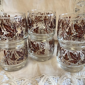 May include: Set of six clear glass tumblers with a brown leaf pattern. The glasses are stacked in pairs.