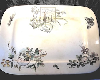 Puede incluir: Un plato rectangular de cerámica blanca con un diseño floral y una escena de veleros en un lago. El plato tiene un diseño floral verde, marrón y amarillo alrededor de los bordes y una escena central de veleros en un lago con un diseño floral verde, marrón y blanco alrededor de la escena.