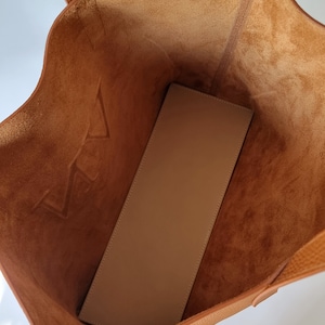 the inside of the bag is shown. This is an unlined leather bag, you can appreciate its beautiful leather also on the inside. It has no pockets, it is a simple and minimalist design.