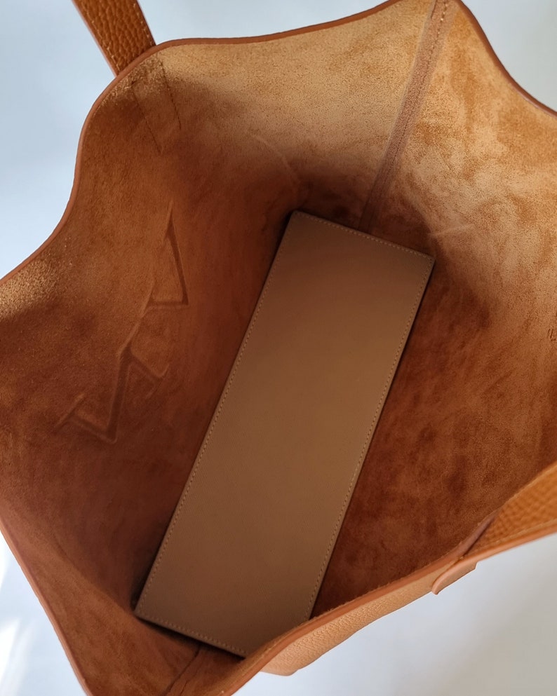 the inside of the bag is shown. This is an unlined leather bag, you can appreciate its beautiful leather also on the inside. It has no pockets, it is a simple and minimalist design.