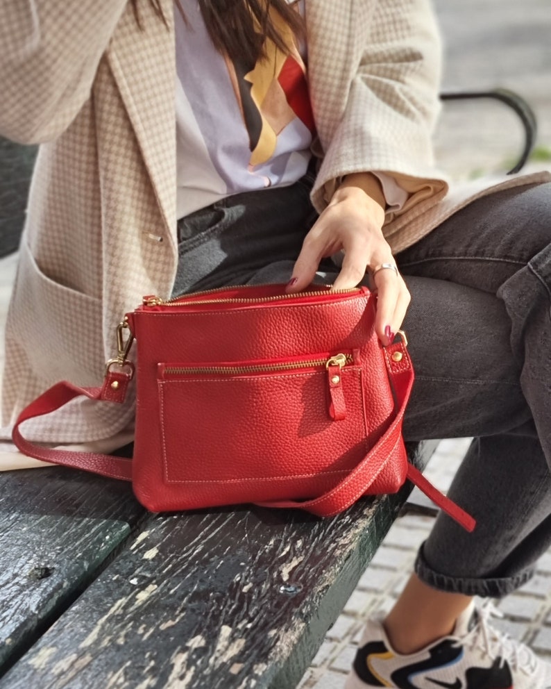 the model is sitting on a bench and the open bag is shown. It really is a perfect bag for an active person's lifestyle.