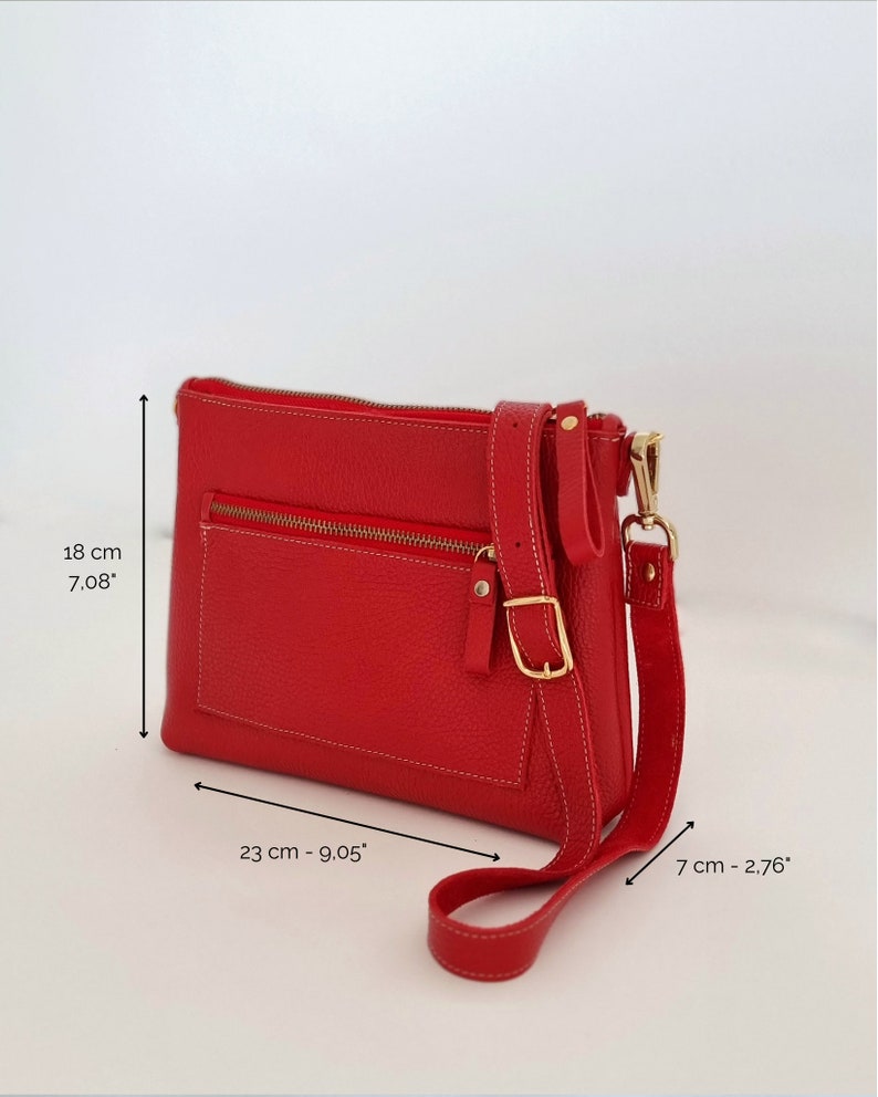 the dimensions of the leather crossbody bag with zipper are shown, being:
18 cm high
23 cm width
7 cm deep