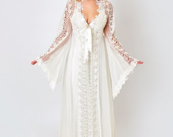 May include: A white lace robe with long sleeves and a V-neckline. The robe has a satin tie at the waist and a flowing skirt.