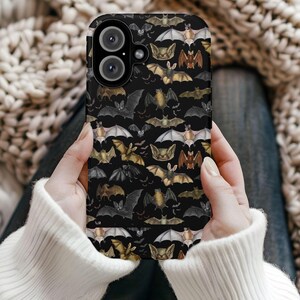 May include: A black phone case with a repeating pattern of bats in various shades of brown, black, and white. The case has a camera lens cutout and a raised lip around the edges.