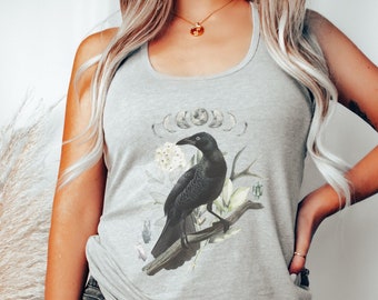 May include: A gray tank top with a black crow illustration and a crescent moon design. The crow is perched on a branch with white flowers.