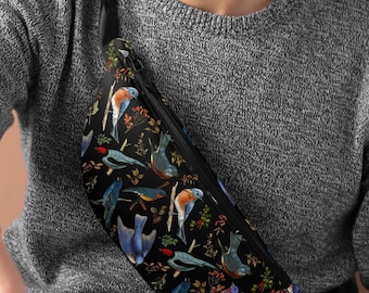 May include: Black fanny pack with a colorful bird and floral pattern. The bag features a zippered closure and an adjustable strap. The design includes blue, red, and yellow birds with green and brown foliage.