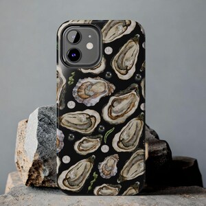 May include: Black phone case with a pattern of oyster shells and pearls.