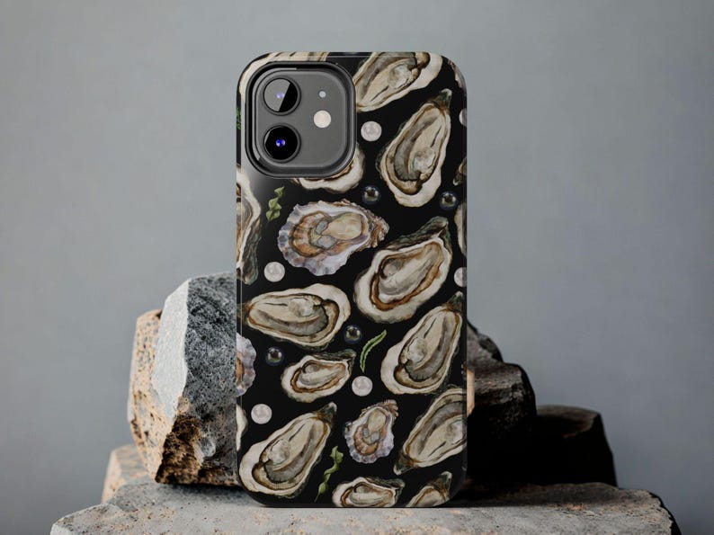 May include: Black phone case with a pattern of oyster shells and pearls.