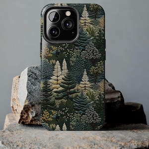 May include: A black phone case with a forest scene design. The case features a repeating pattern of green, brown, and yellow trees.