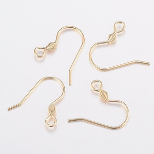 May include: Four gold-toned earring hooks with a wire wrapped loop at the top. The hooks are made of metal and are designed for hanging earrings.