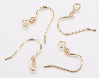 May include: Four gold-toned earring hooks with a wire wrapped loop at the top. The hooks are made of metal and are designed for hanging earrings.