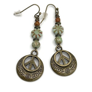 a pair of earrings with a peace sign on it