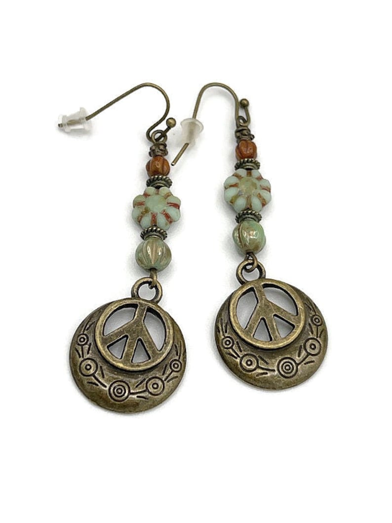 a pair of earrings with a peace sign on it