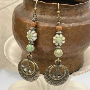 a pair of earrings sitting on top of a cup