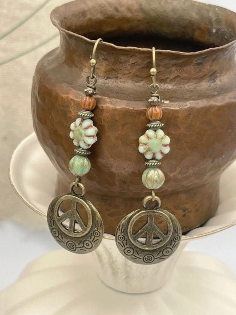 a pair of earrings sitting on top of a cup