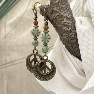 a close up of a pair of earrings on a tree branch