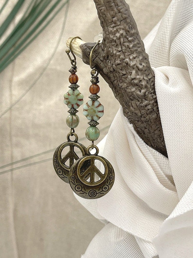 a close up of a pair of earrings on a tree branch