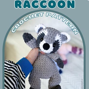 Könnte beinhalten: Ein gehäkeltes Waschbär-Spielzeug in Grau-, Weiß- und Schwarztönen. Der Text "RILEY THE RACCOON CROCHET PATTERN" wird über dem Spielzeug angezeigt. Die Worte "DIGITAL DOWNLOAD" stehen am unteren Rand des Bildes.