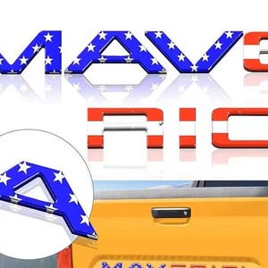 May include: Blue and white star-patterned letters spelling "MAVERICK" with red and white striped letters. The letter "A" is shown in a circle. The letters are displayed on a white background and on a yellow truck.