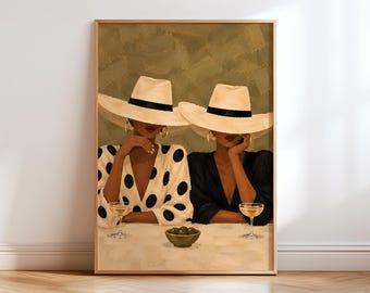 May include: A framed art print depicting two figures wearing wide-brimmed straw hats with black bands. One figure wears a white blouse with large black polka dots, the other a black blouse. Both hold stemmed glasses near a bowl of olives.