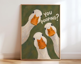May include: A framed wall art print featuring an oil painting of three white ducks with orange beaks against a dark olive green background. The ducks are looking forward with curious expressions. The text YOU POOPING? is written in white.