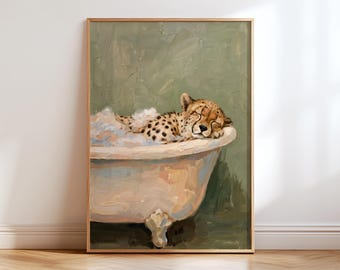 May include: A framed wall art print featuring an oil painting of a cheetah cub resting inside a light-colored clawfoot bathtub filled with white bubbles. The background is a muted sage green with visible brushstrokes throughout the artwork.