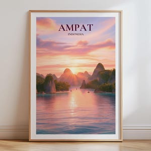 May include: A framed wall art print featuring a sunset over the islands of Ampat, Indonesia. The image displays rocky, green-covered islands rising from calm water under a pink and orange sky. The text AMPAT INDONESIA is printed at the top.
