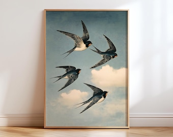 May include: A rectangular framed wall art print featuring four swallows in flight against a light blue sky with soft white clouds. The birds have dark blue and black plumage with white underbellies and long, pointed, forked tail feathers.