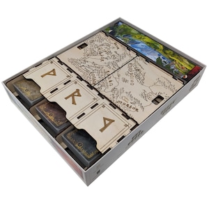 Könnte beinhalten: Ein hölzerner Spielorganizer mit Fächern, die mit "P", "I", "R", "A" und "T" beschriftet sind. Der Organizer hat eine Karte einer Fantasiewelt auf der Oberseite.